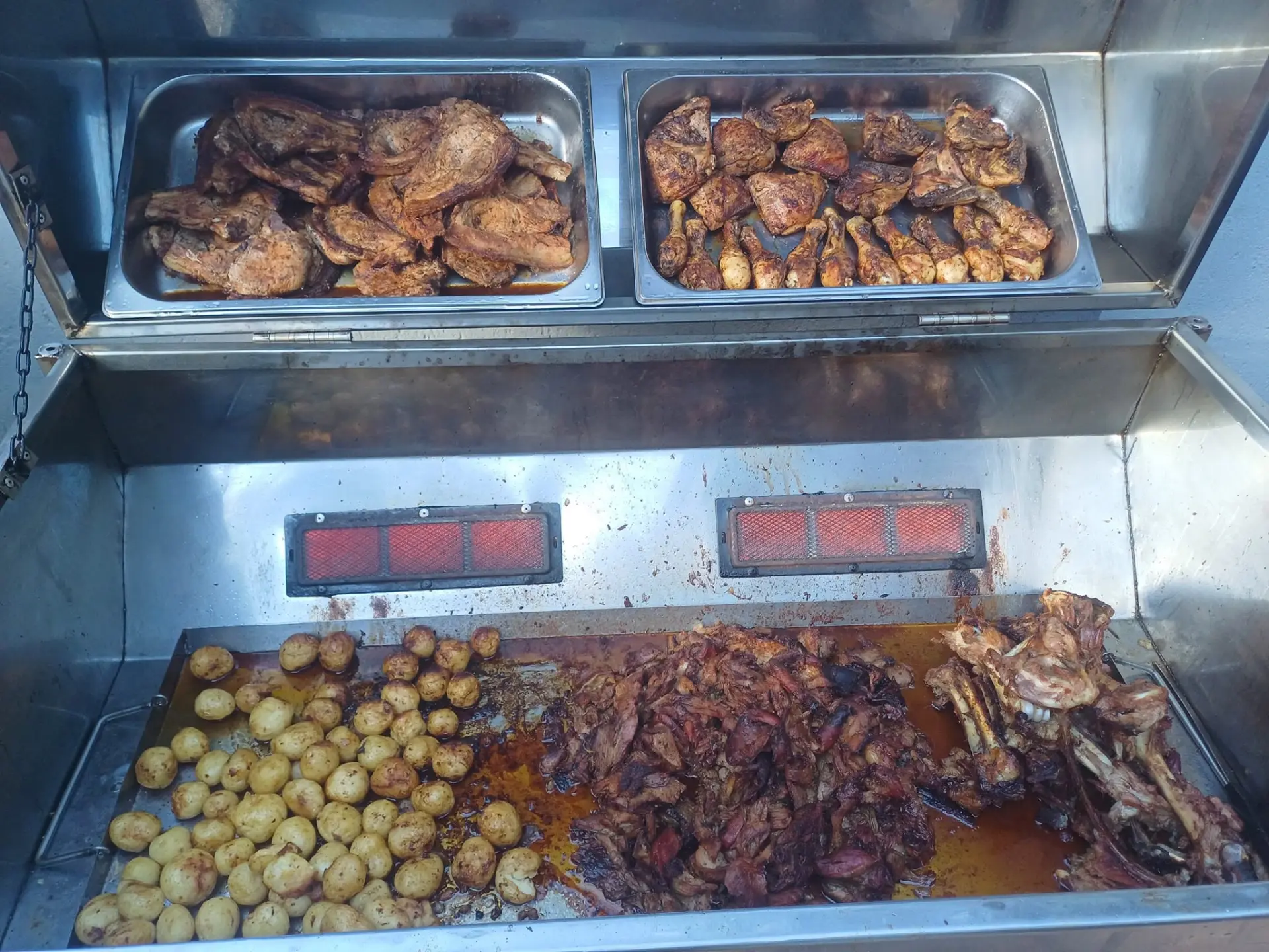 Spit braai trays of chops, chicken, pulled lamb and baby potatoes