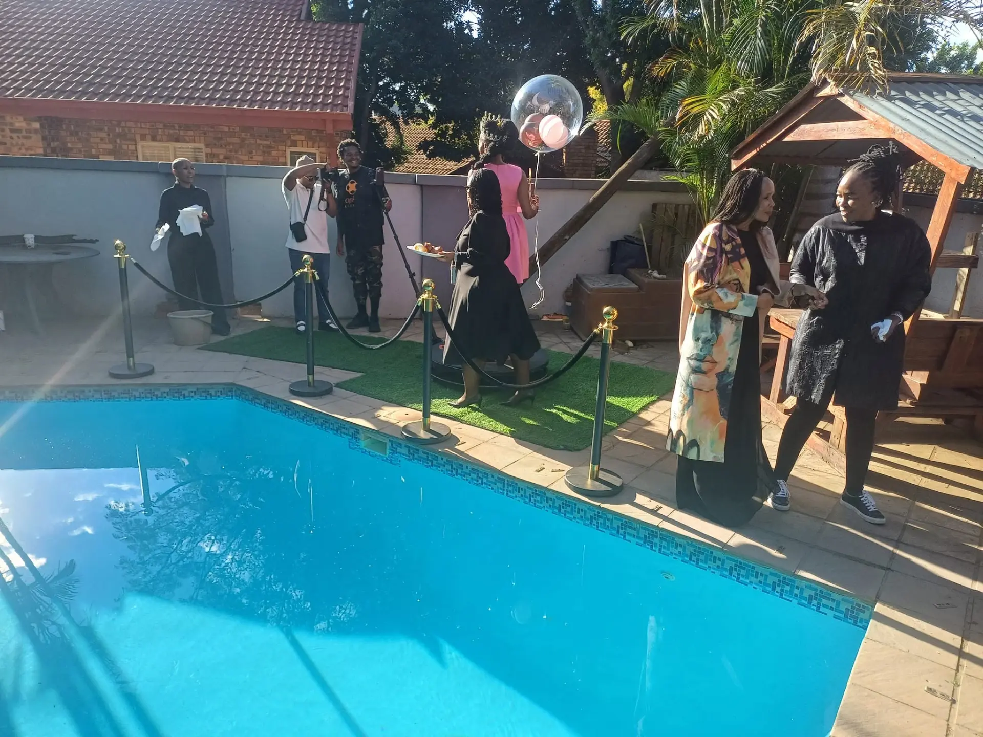 Guests gathered around a 360 photo booth by the pool