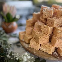 Stack of golden-brown cubed bites on a platter with flowers and greenery
