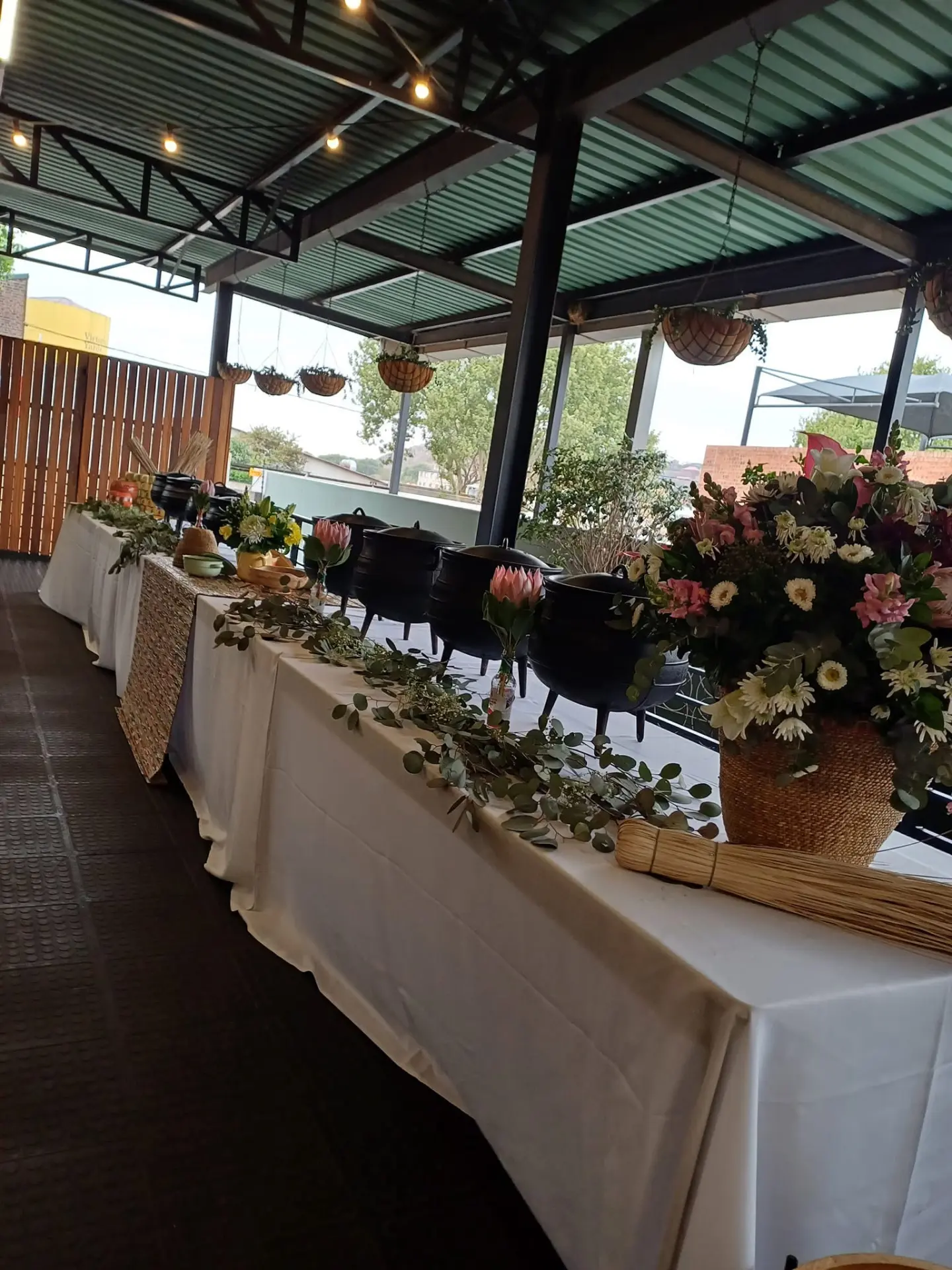 Buffet line with potjie pots, white linen and floral arrangements