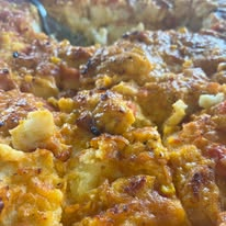 Cooked golden-brown mixed dish with chunks and sauce