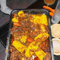 Tray of cooked meat and corn in a rich sauce, ready to serve