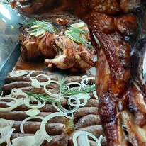 Serving platter of assorted roast meats garnished with onions and herbs