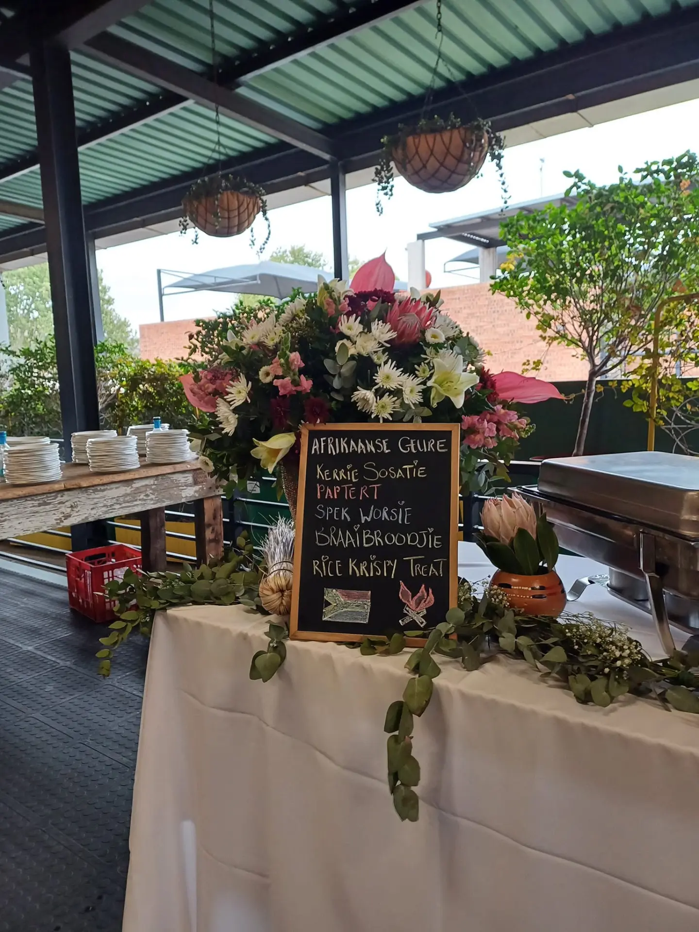 Chalkboard menu with proteas and flowers on the buffet table